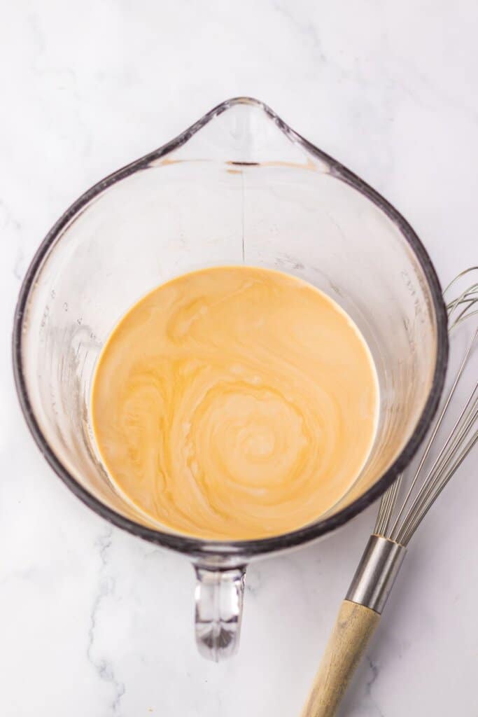 coffee and creamer being mixed together in a large mixing bowl.