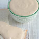Half slice of bread topped with amish peanut butter spread on the counter.