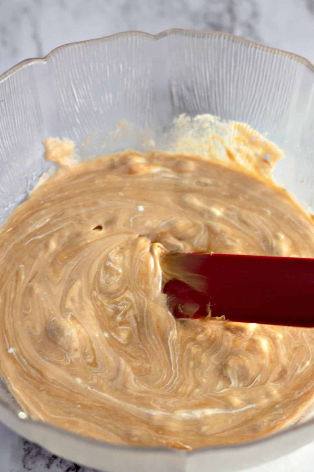 Ingredients being mixed in a large glass bowl.