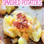 bacon cheddar smashed potaotes on a dark baking sheet.