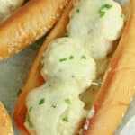 three chicken meatball subs on a parchment lined basket.