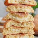 6 halves of churro cheesecake cookies stacked on top of each other on a counter.