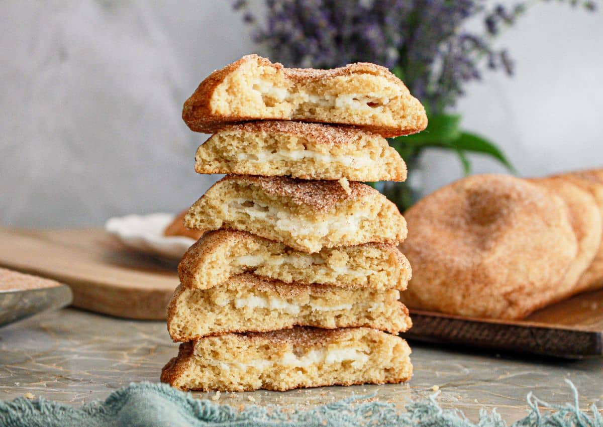 6 halves of churro cheesecake cookies stacked on top of each other on a counter.
