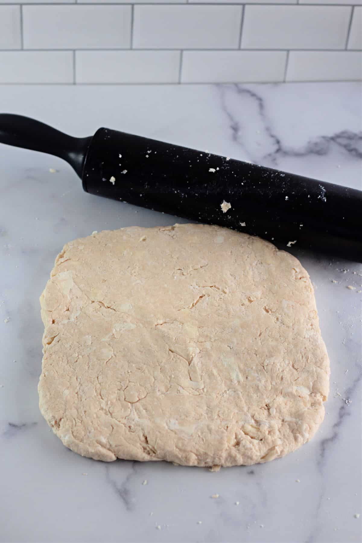 biscuit dough rolled out on a counter.