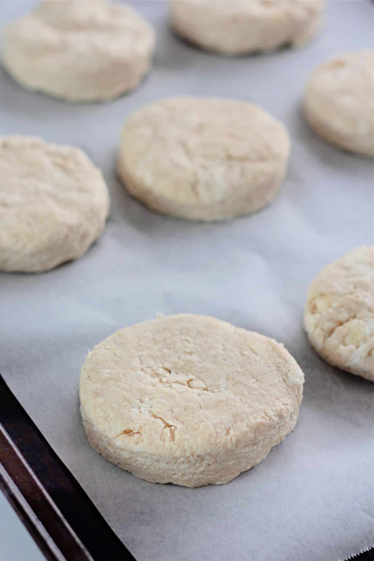 raw biscuit dough on a parchment lined baking sheet.