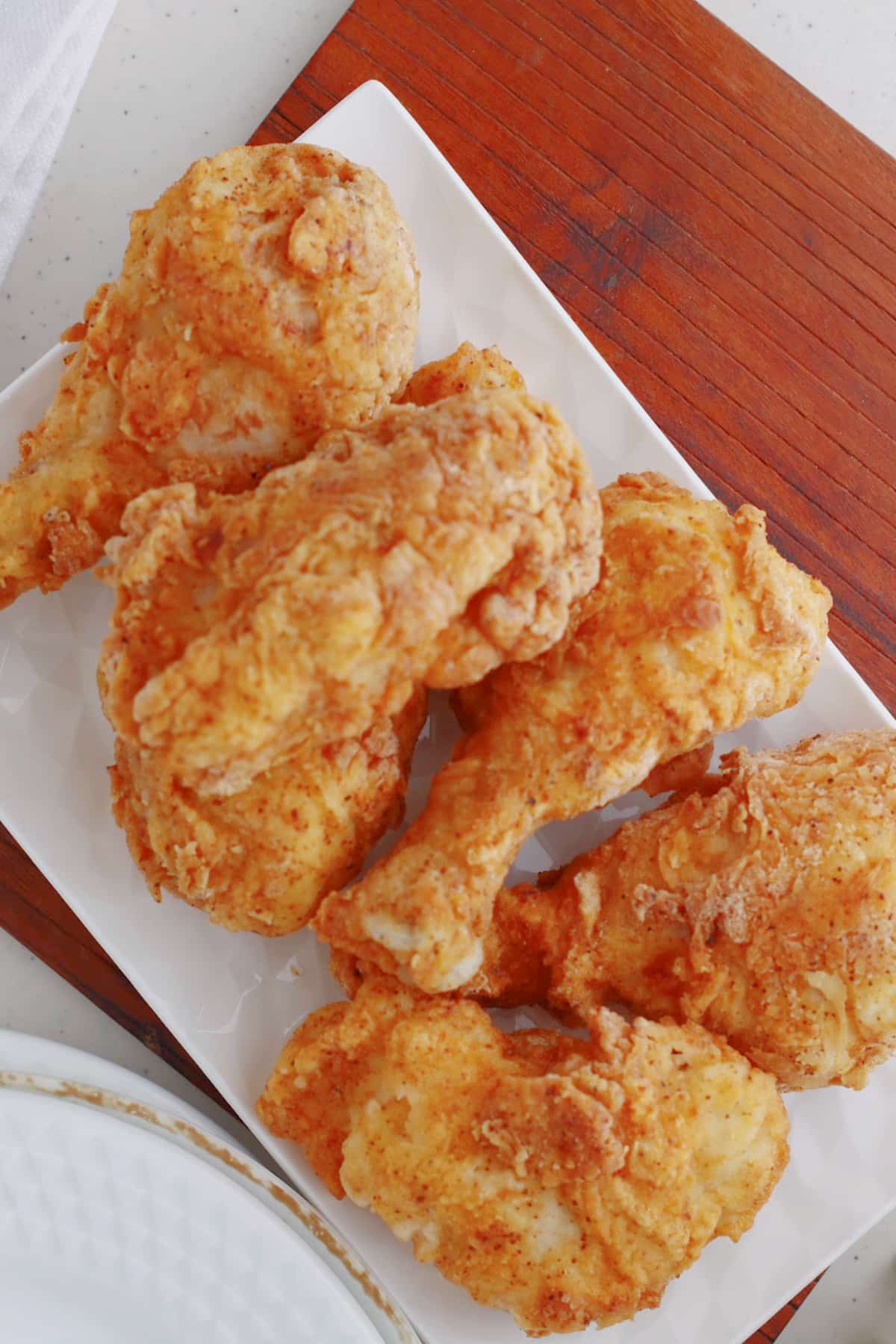 louisiana fried chicken stacked on a serving platter.