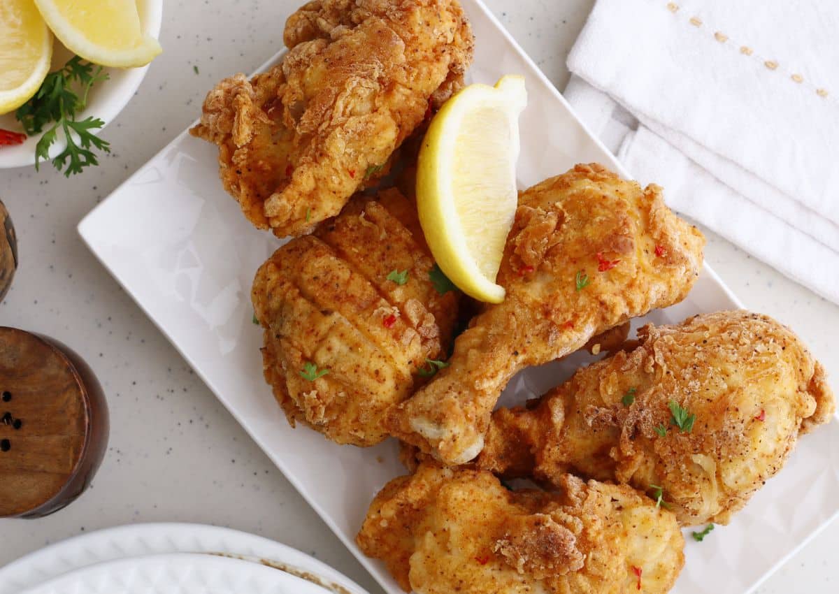louisiana fried chicken stacked on a serving platter.