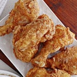 louisiana fried chicken stacked on a serving platter.