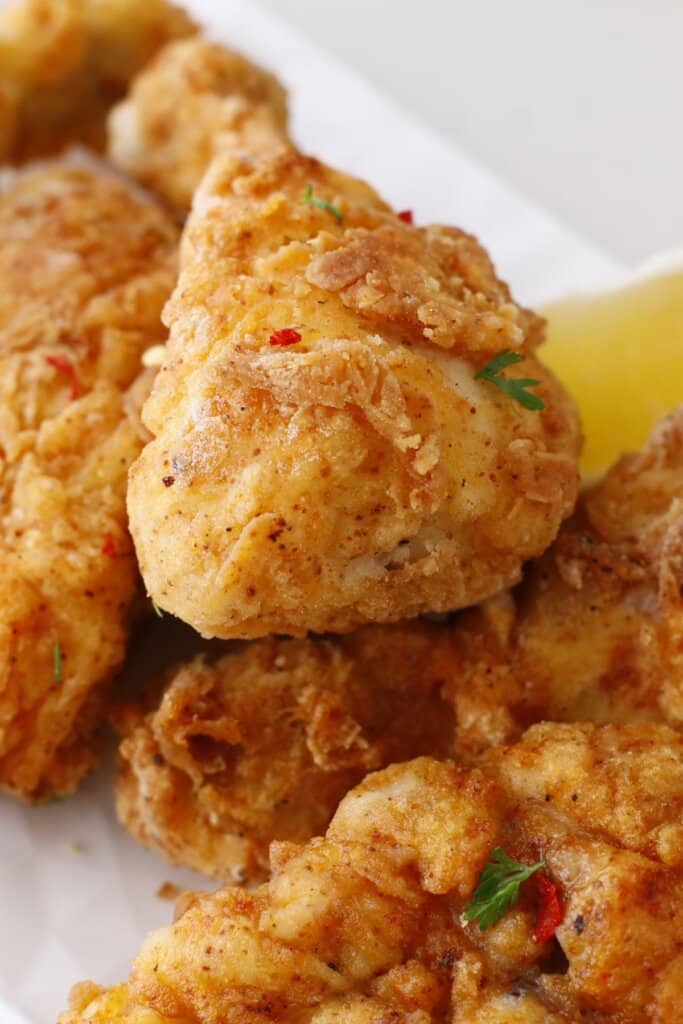 louisiana fried chicken stacked on a serving platter.