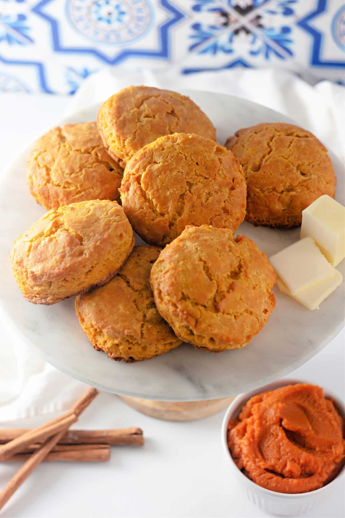 Seven pumpkin buttermilk biscuits on a plate.