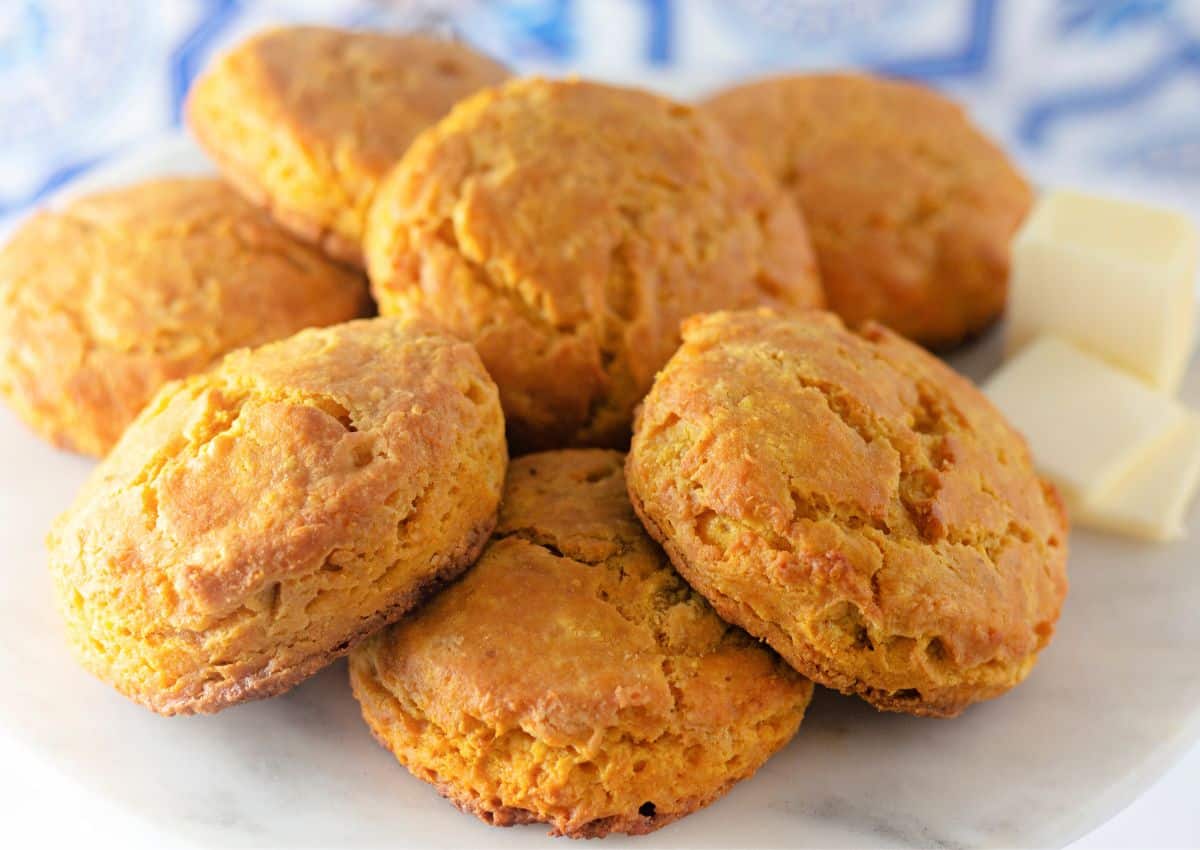 Seven pumpkin buttermilk biscuits on a plate.