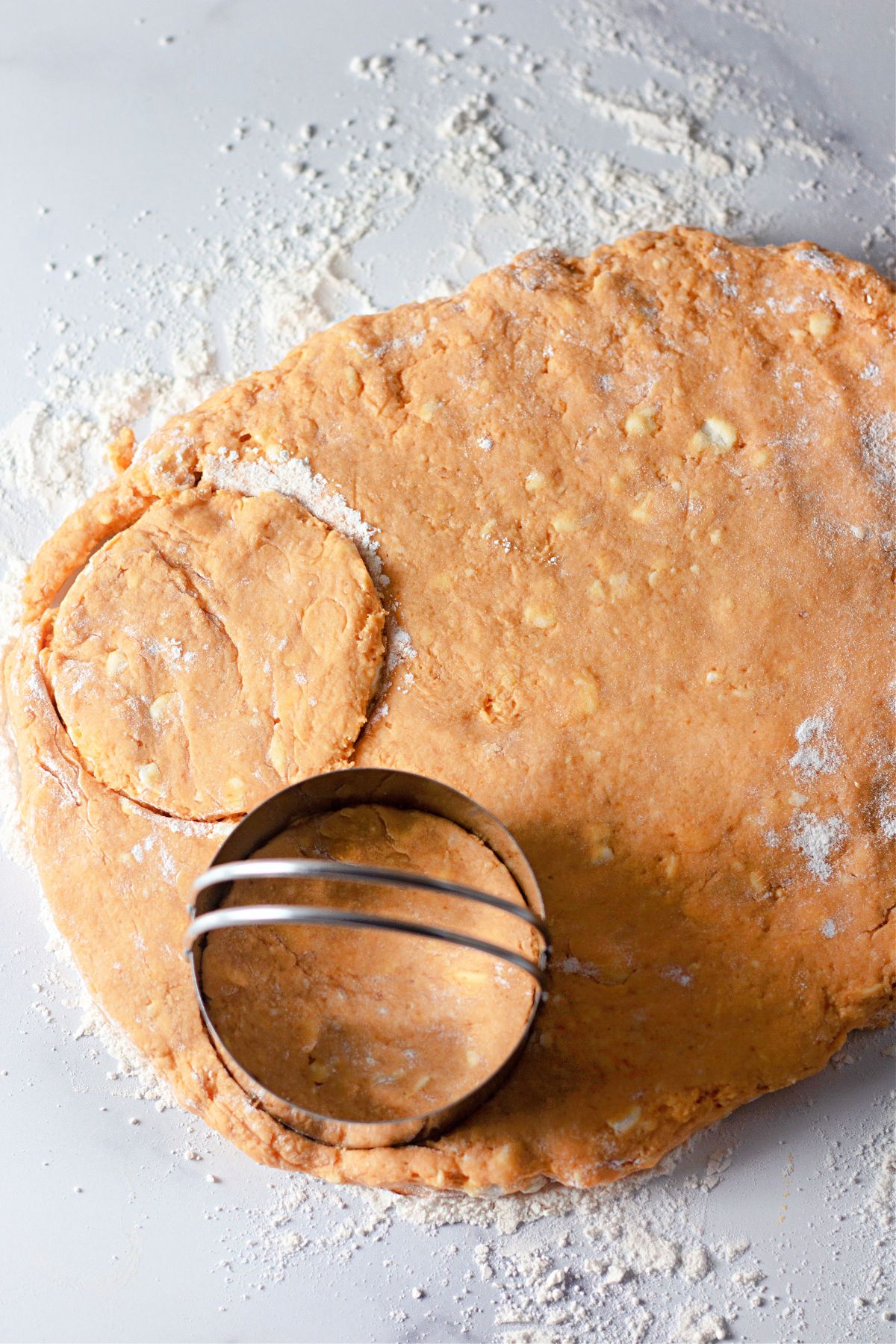 Biscuit dough being cut into circles.