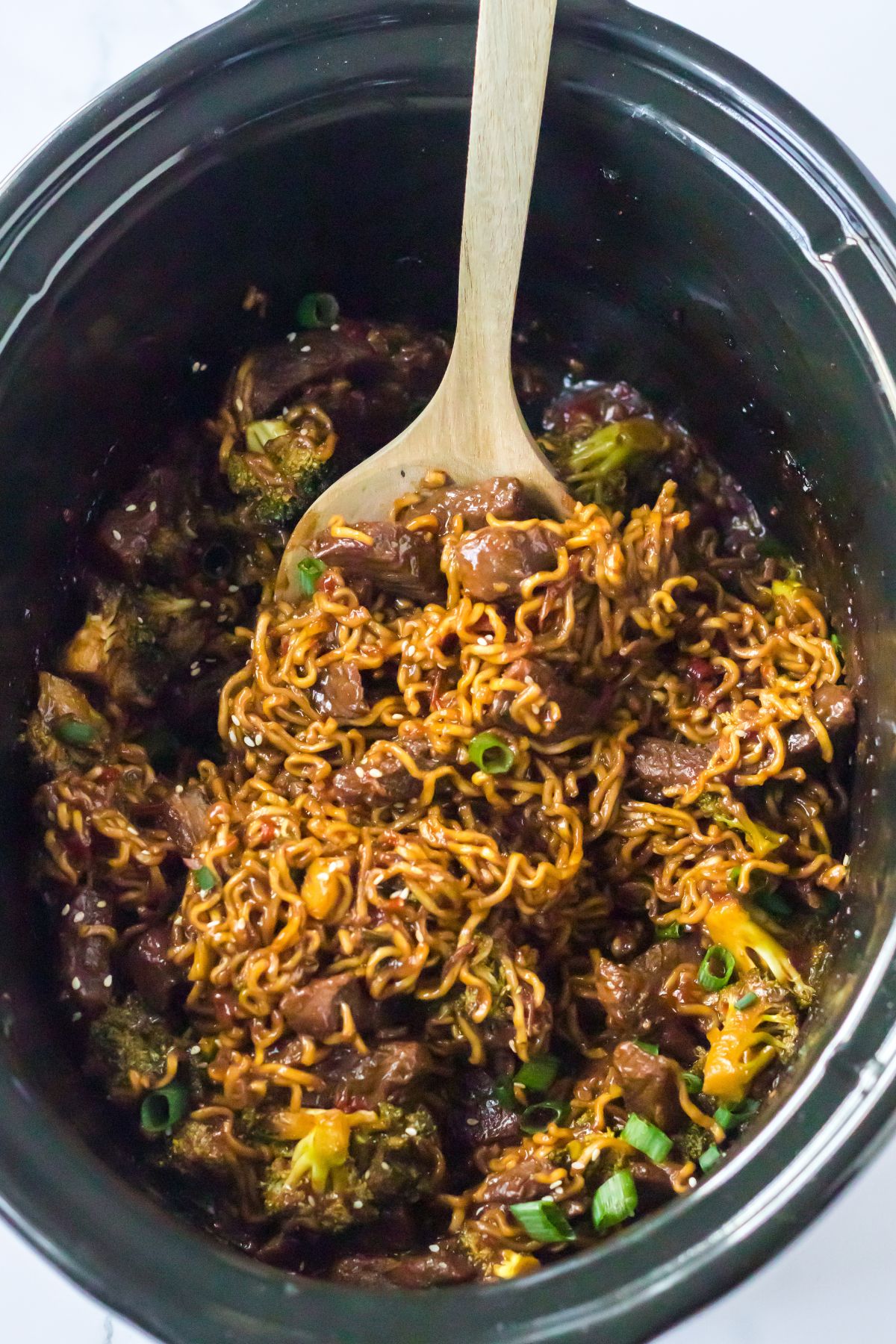 Slow cooker filled with beef and ramen ready to be served.