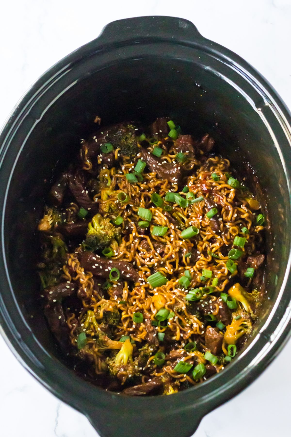 Slow cooker full of beef ramen ready to serve.