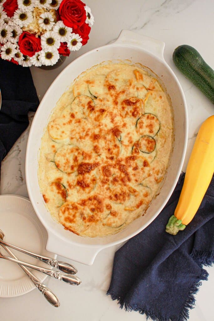 uncut zucchini and squash au gratin in a casserole dish.