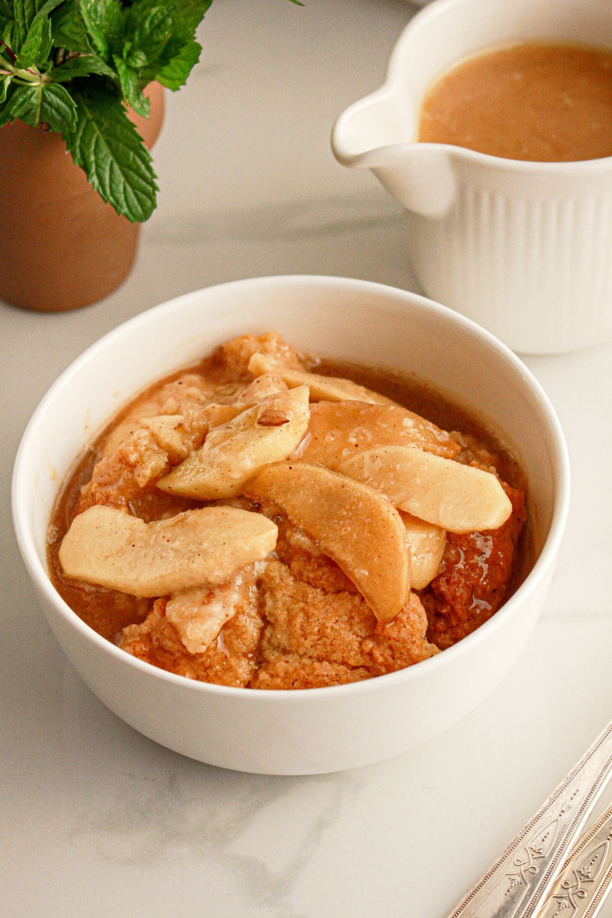 Bowl full of caramel apple cobbler on a counter.