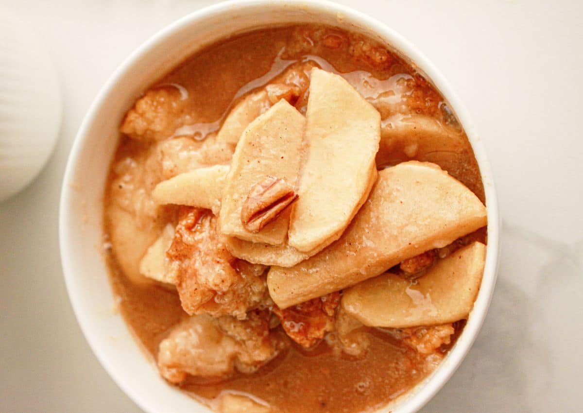 Bowl full of caramel apple cobbler on a counter.