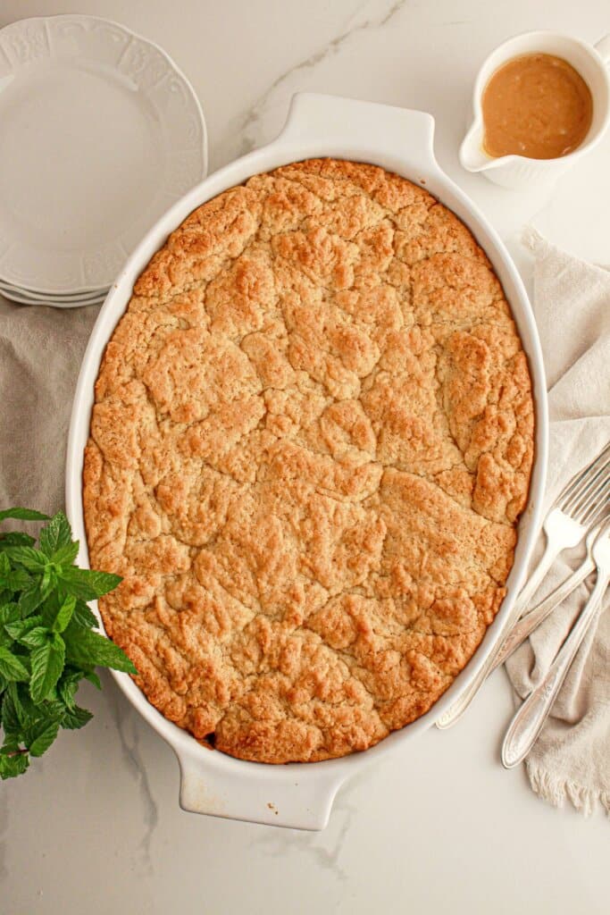Caramel apple cobbler in a casserole dish on a table.