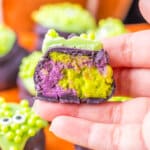 Cauldron Oreo Truffle split in half and held in a woman's hand.