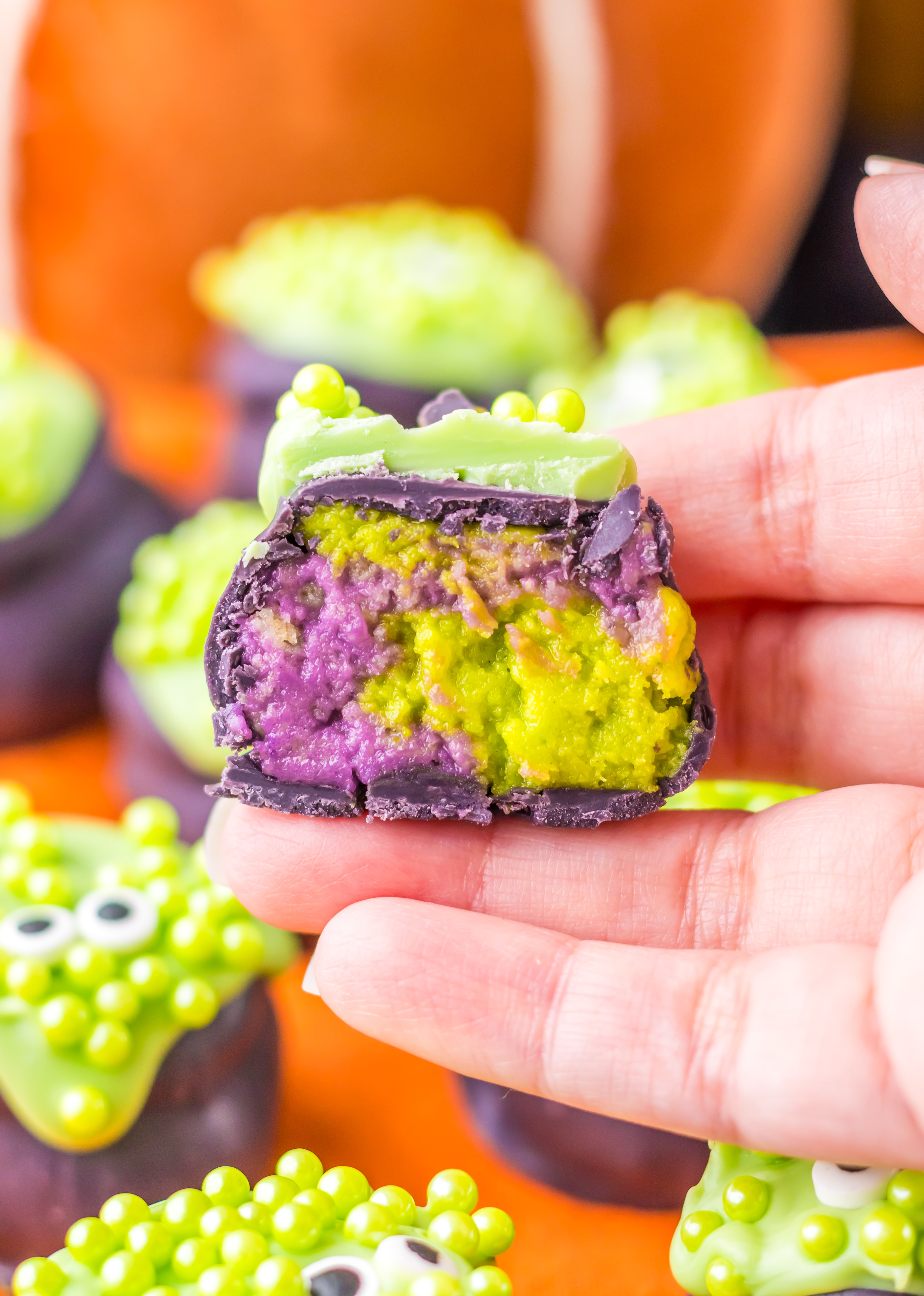 Cauldron Oreo Truffle split in half and held in a woman's hand.