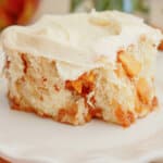 Peach cobbler cinnamon roll on a small plate on a table.