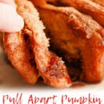 Pieces of pumpkin pull apart pumpkin bread on a plate.