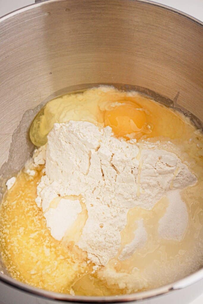 Dough ingredients being added to a stand mixer.