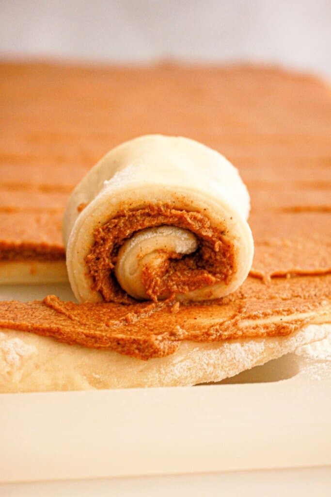 Strip of dough being rolled tightly.