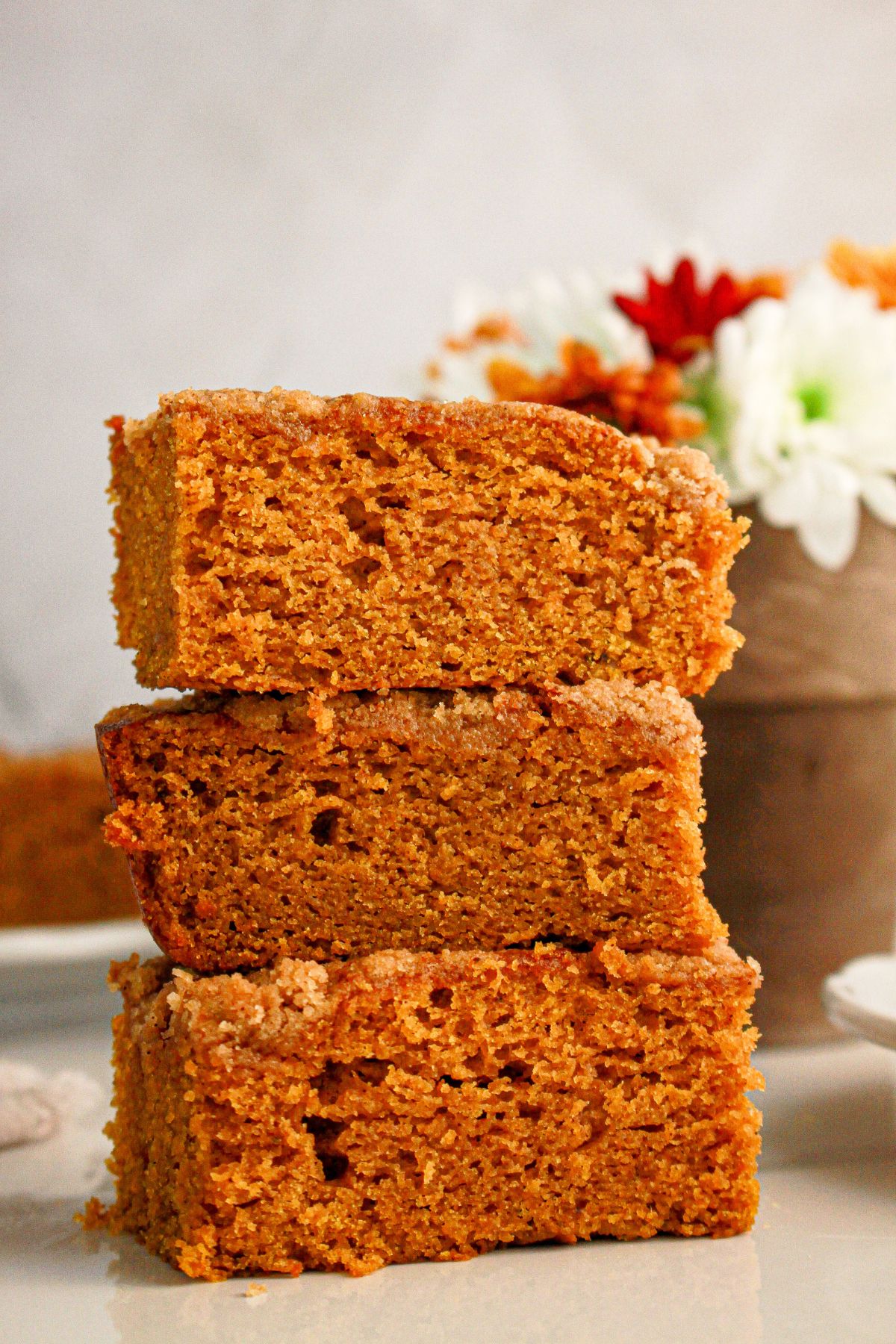 Three slices of pumpkin coffee cake on a counter.