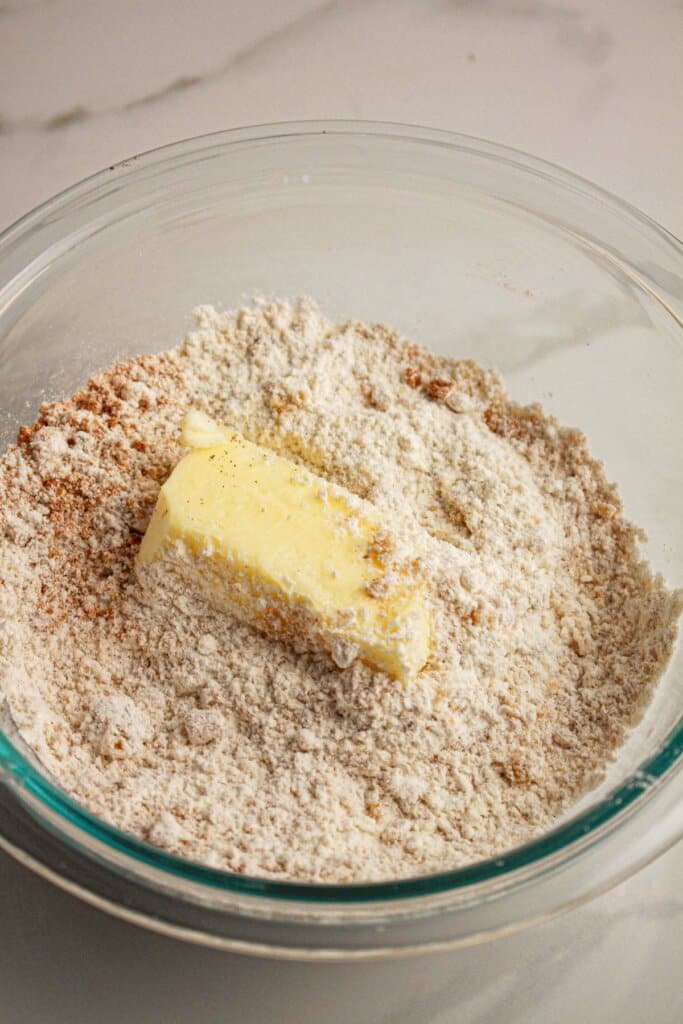 Butter, flour, and brown sugar being mixed together.