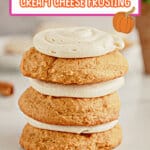 Three pumkin cookies stacked on top of each other on a counter.