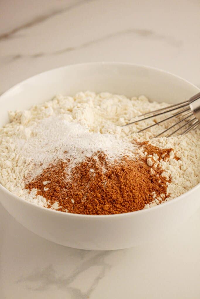 Flour, salt, and pumpkin pie spice being mixed in a small bowl.