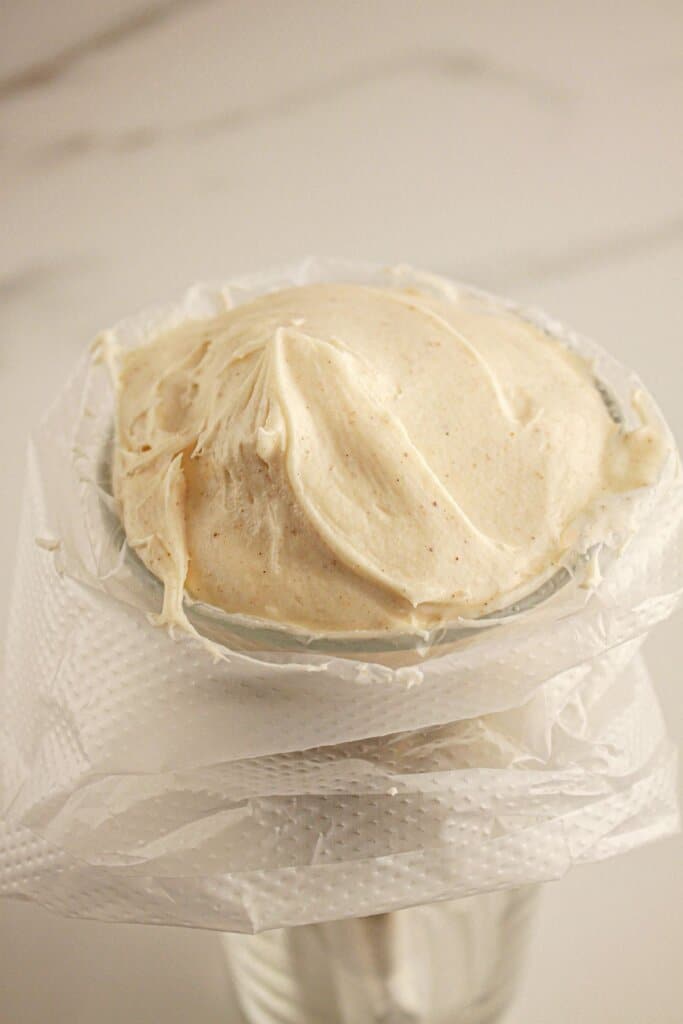 Cream cheese frosting being added to a piping bag.