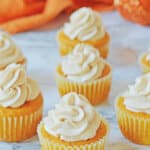 Seven pumpkin cupcakes on a counter.