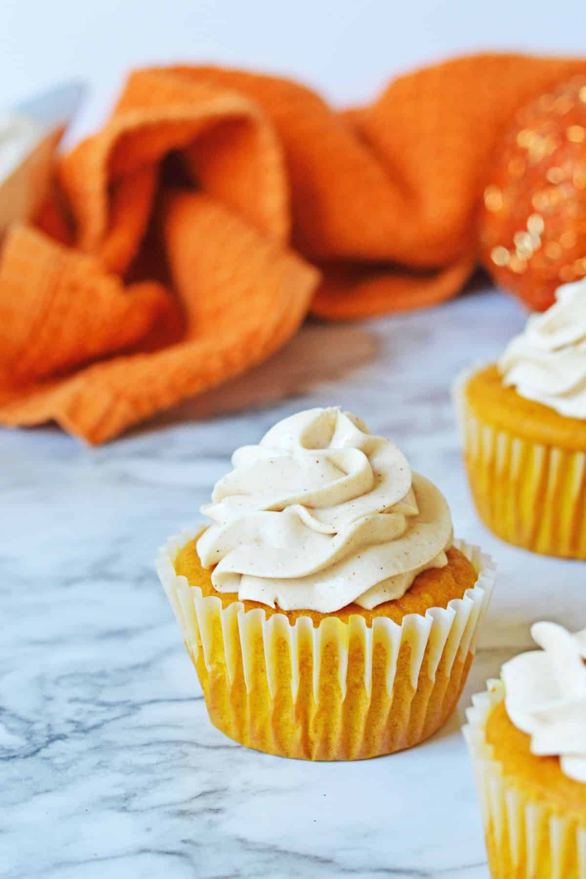 Seven pumpkin cupcakes on a counter.