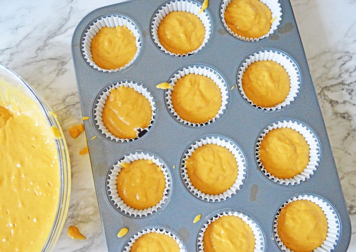 Cake batter in a muffin pan ready for the oven.