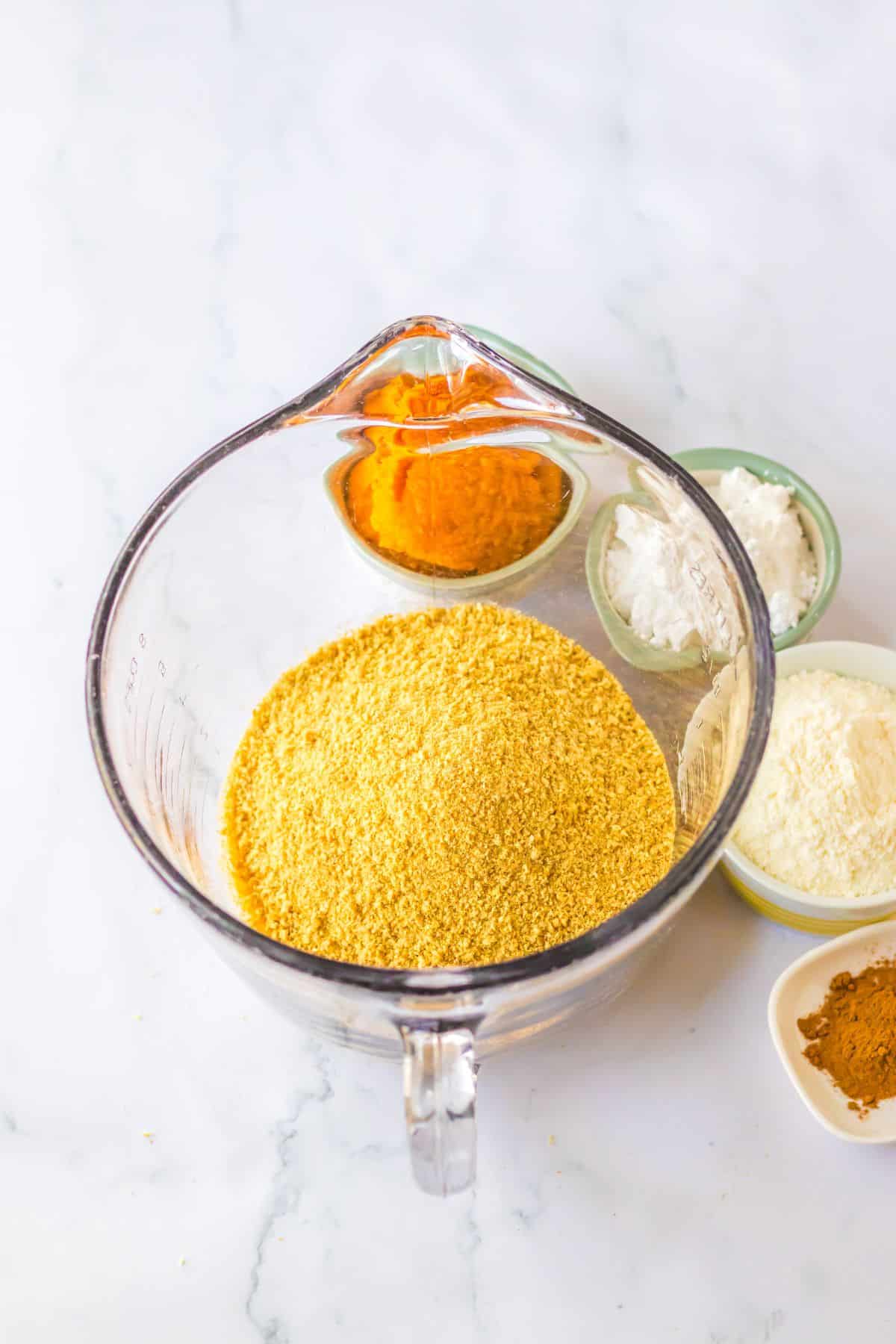 Graham cracker crumbs in a large mixing cup ready to make the crust.