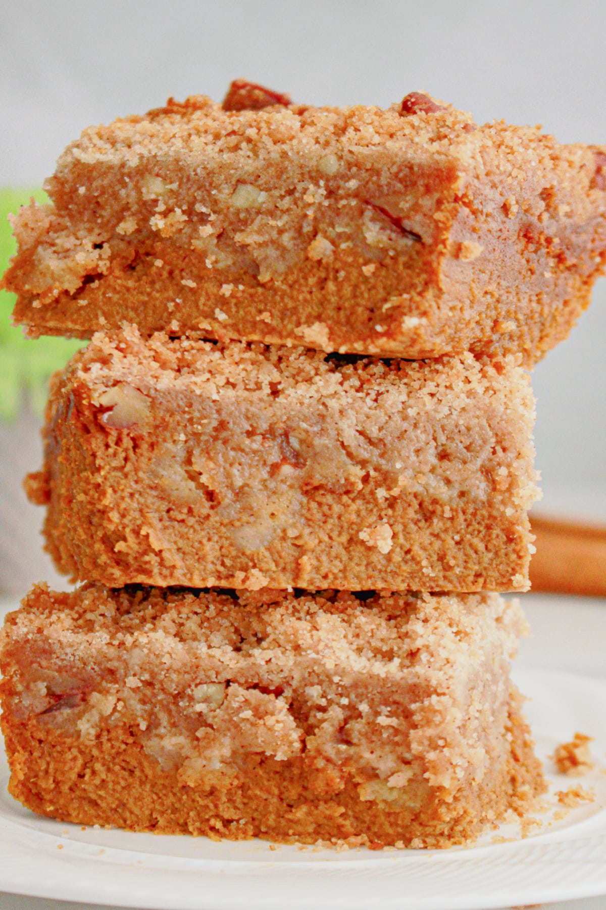 Three slices of pumpkin pie crisp stacked on top of one another on a plate.