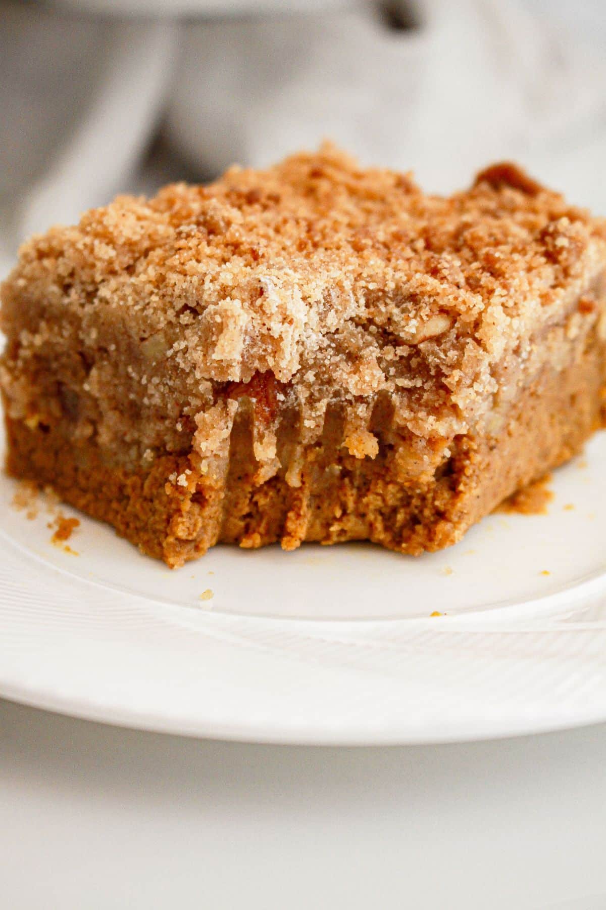 Sllice of pumpkin pie crisp on a plate with a bite misisng.