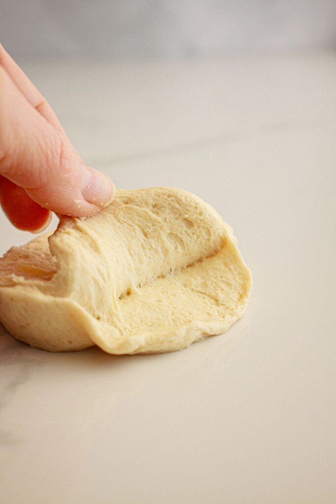 Canned biscuit being seperated into layers.