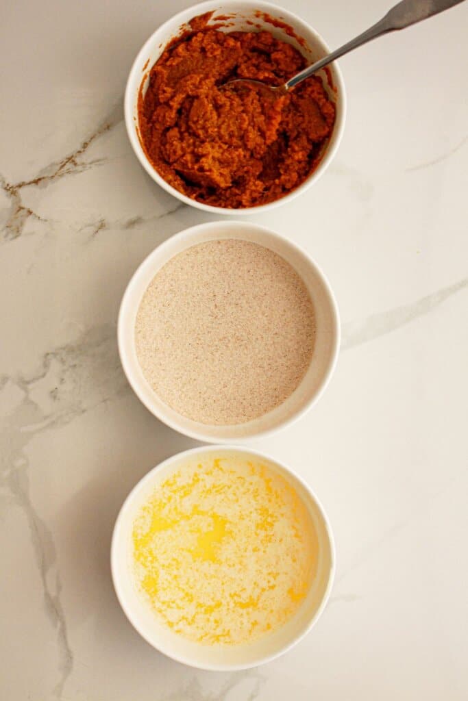 Bowls of pumpkin mixture, cinnamon sugar, and melted butter.