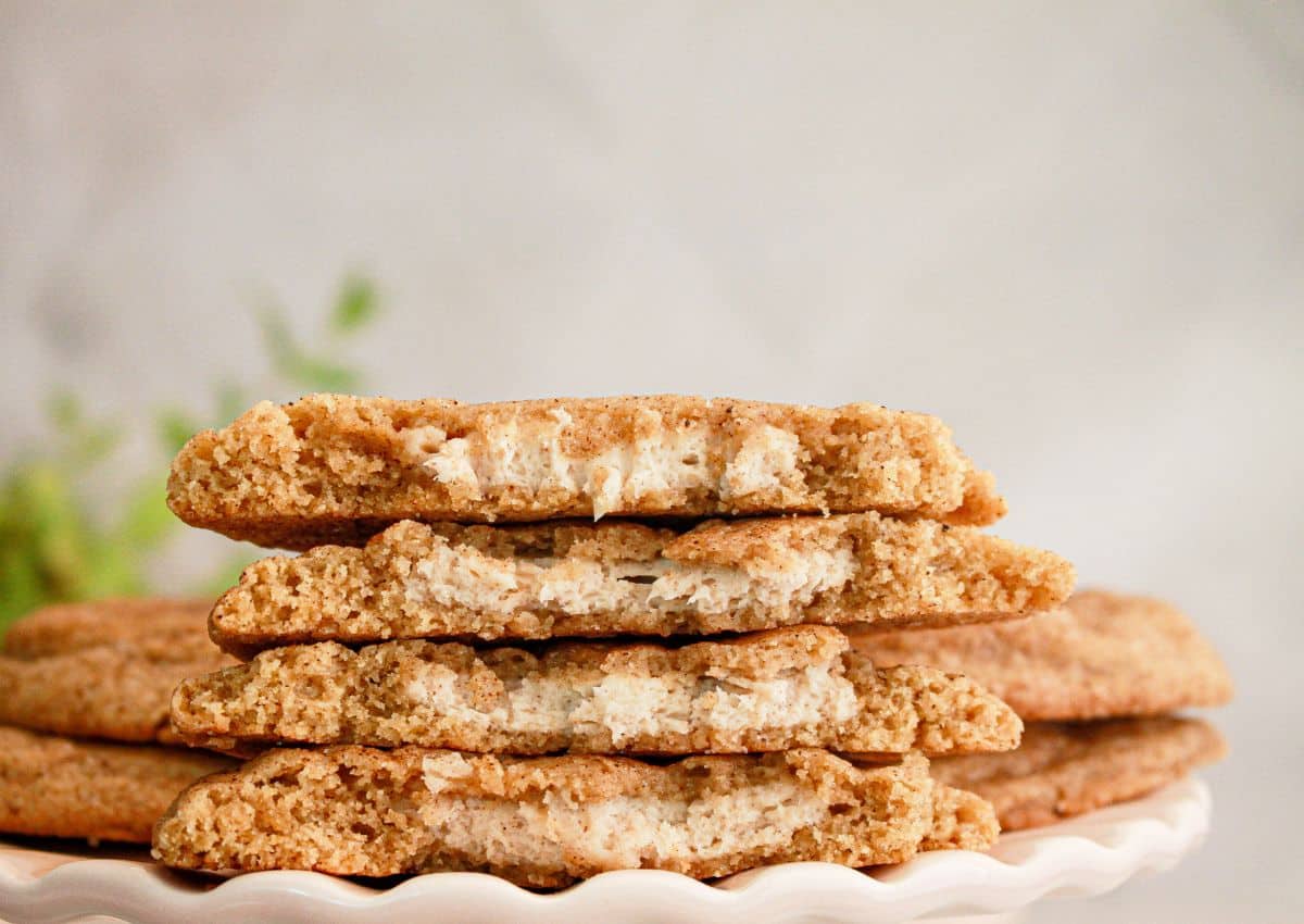 Two pumpkin spice cheesecake cookies broken in half stacked on top of each other.
