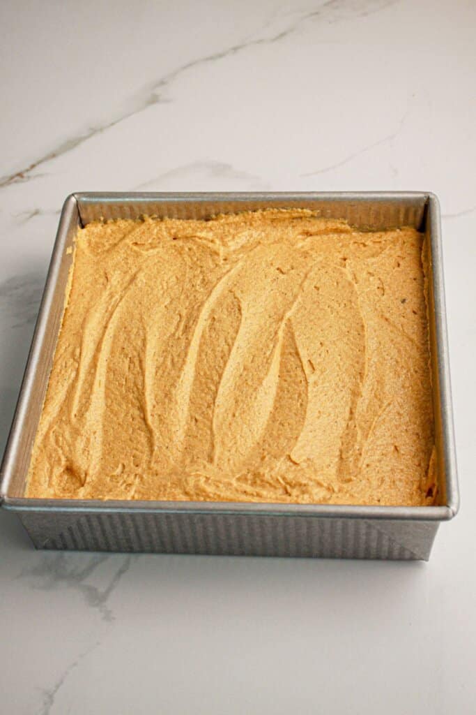 Batter being spread into a baking pan.