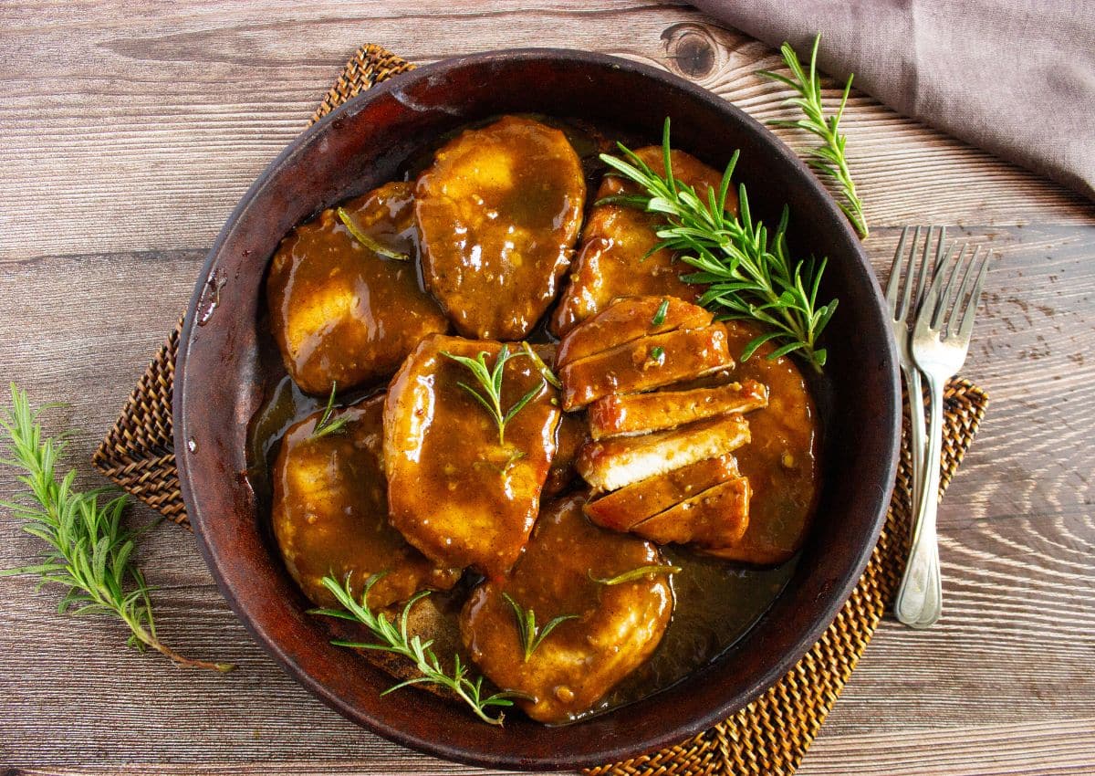 Pork chops in a skillet.