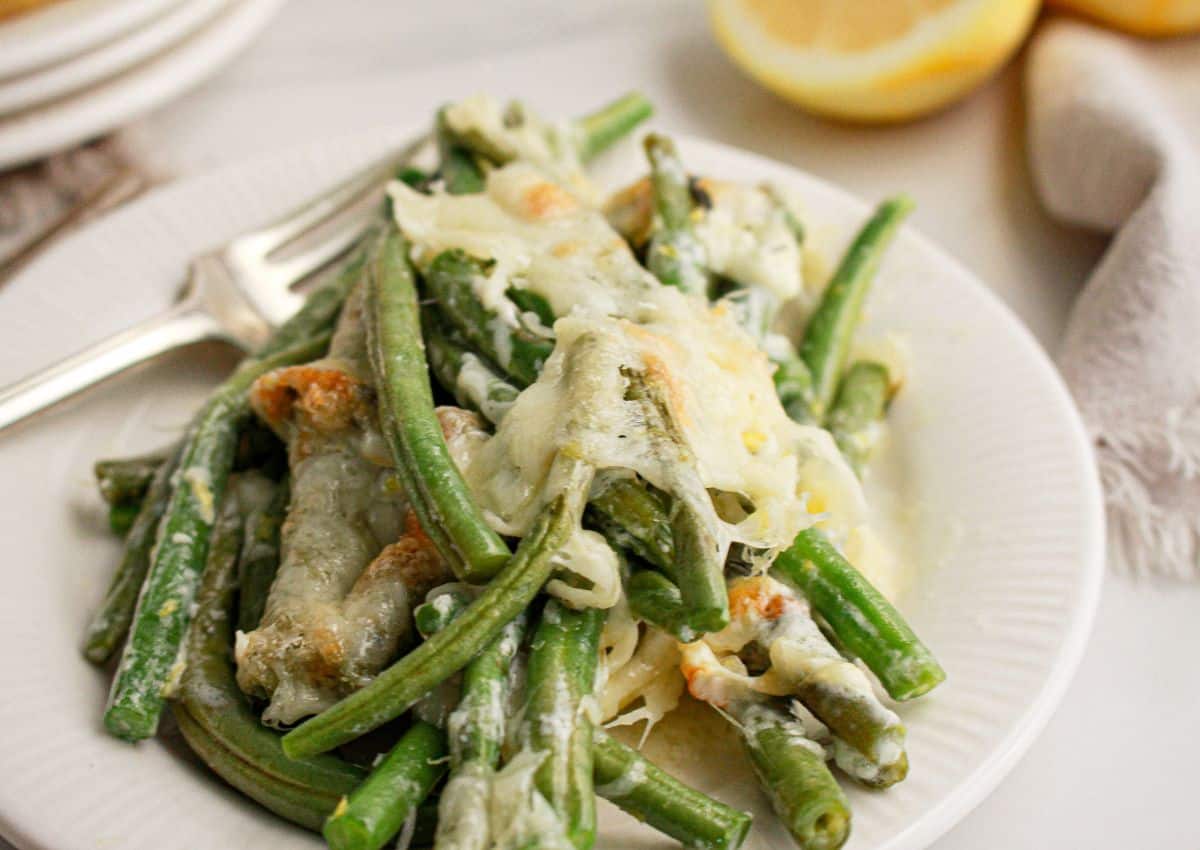 Green beans topped with mozzarella cheese on plate.