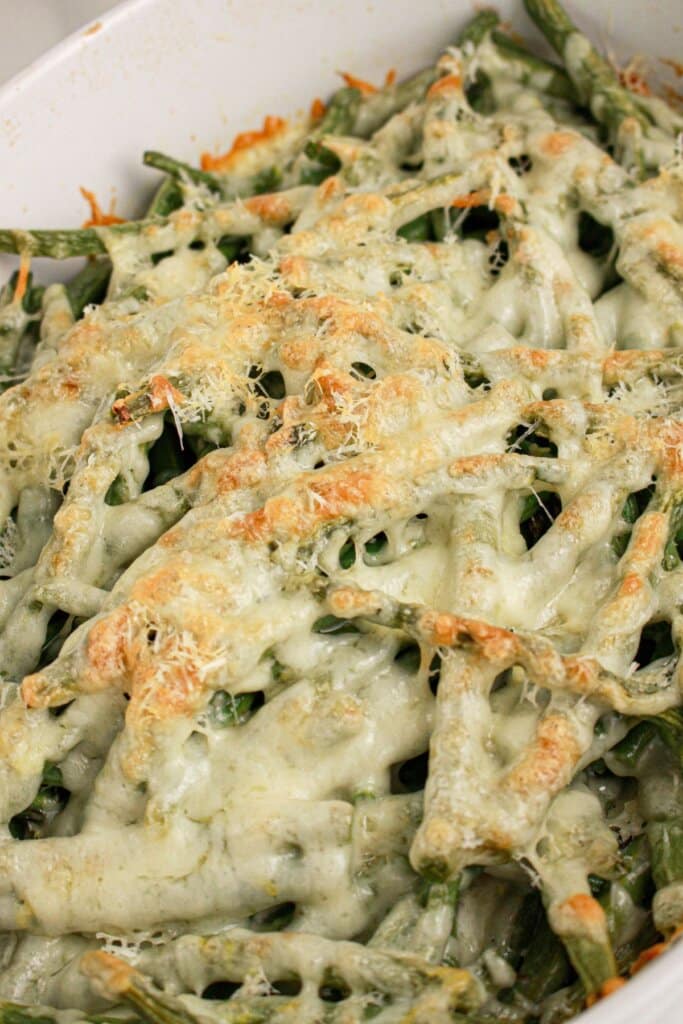 Green beans topped with mozzarella cheese on plate.