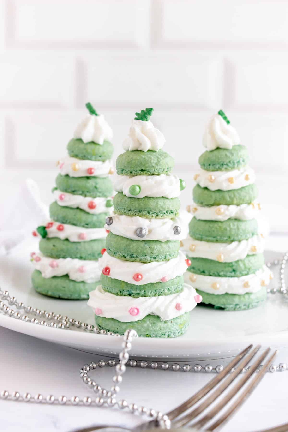 Christmas tree macarons on plate.