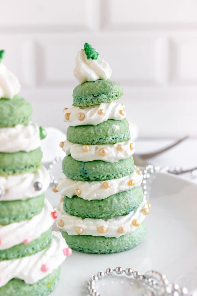 Christmas tree macarons on plate.