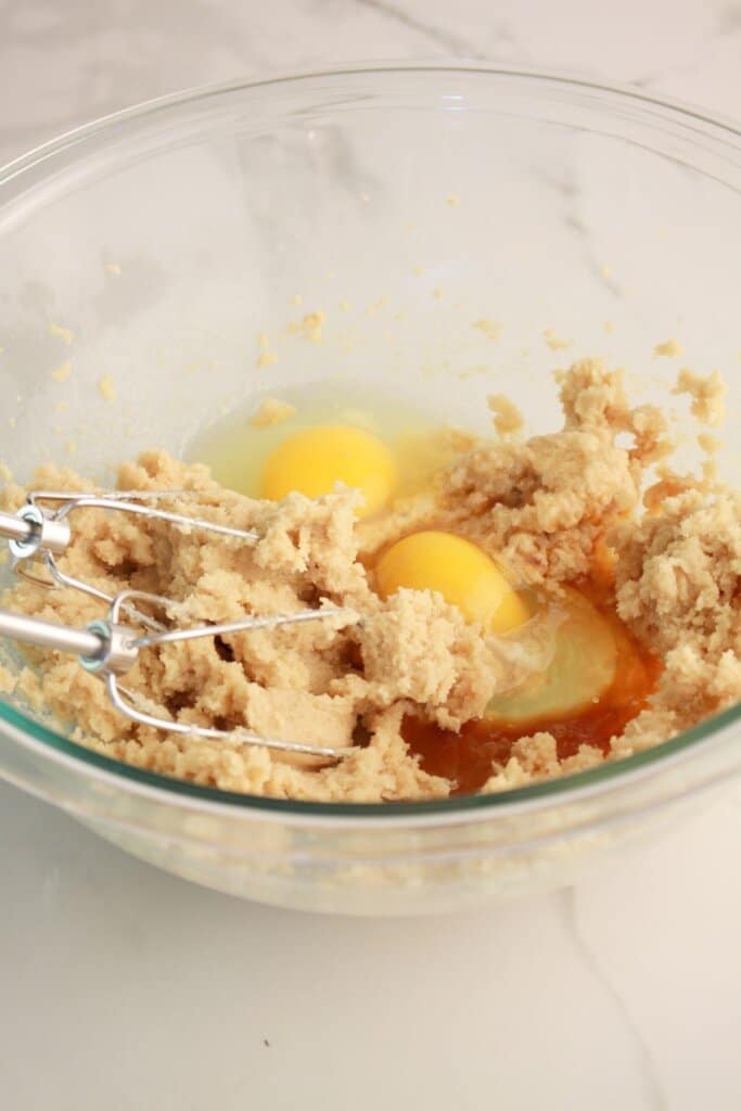 Butt,er sugar, and eggs in a mixing bowl.