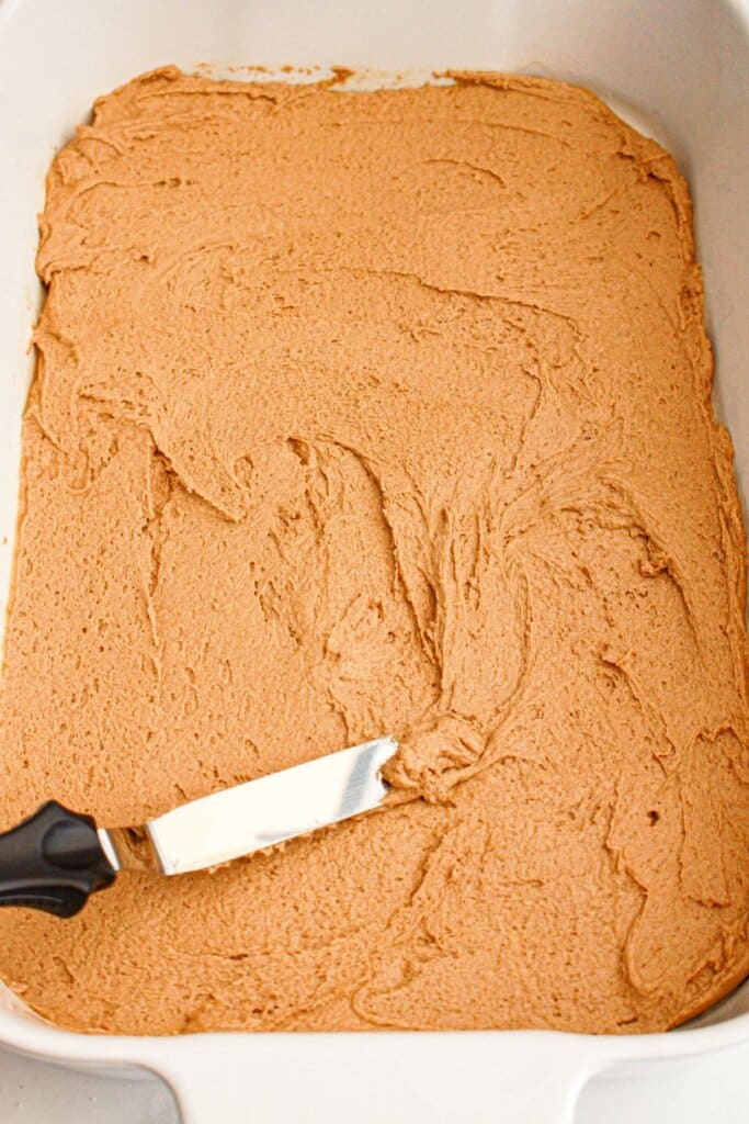 Dough being spread in baking dish.